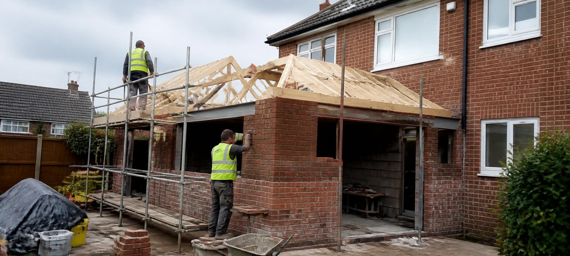 UK brick house extension under construction with builders